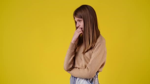 黄色の背景でパニック状態の1人の女の子の4Kビデオ 感情の概念 — ストック動画