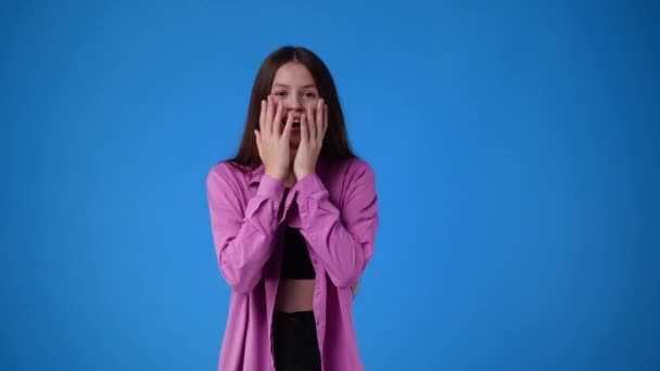 Видео Девушка Поднимает Руки Удивлении Глядя Камеру Большими Глазами Синем — стоковое видео