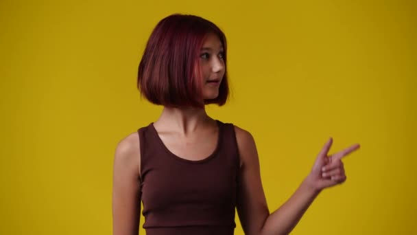 Wideo Dziewczyny Wskazującej Prawą Stronę Pokazującej Kciuk Żółtym Tle Pojęcie — Wideo stockowe
