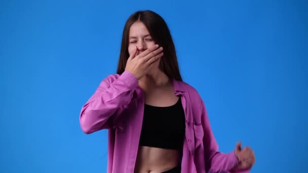 4Kビデオの眠い女の子Yawningと青の背景に彼女の腕を伸ばします 感情の概念 — ストック動画