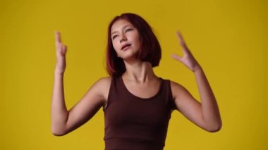 4K videoda kız kendini çok ateşli hissediyor ve ellerini yüzünün önünde hareket ettiriyor. Duyguların kavramı.