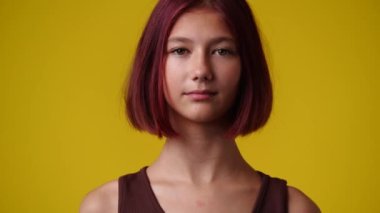 Sarı arka planda bir kızın boş duygularının 4k videosu. Boş duygu kavramı.