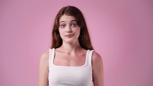 ピンクの背景に無音サインを示す1人の少女の4K動画 感情の概念 — ストック動画