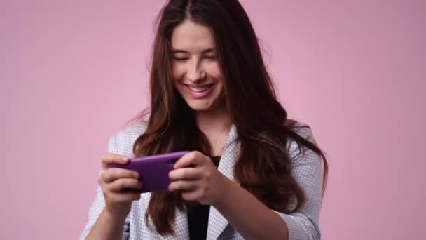ピンクの背景の上に隔離された電話を使用して女性の4Kビデオ 技術の概念 — ストック動画