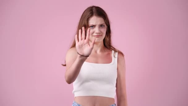 ピンクの背景で意見の相違を示す1人の少女の4Kビデオ 感情の概念 — ストック動画