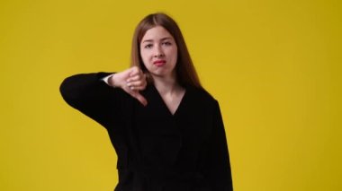 Sarı arka planda başparmağını gösteren 4K video. Olumsuz duygu kavramı.