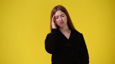 Sarı arka planda güzel bir kızın kafasına dokunduğu 4k 'lık video. Duyguların kavramı.