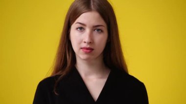 Sarı arka planda bir kızın boş duygularının 4k videosu. Boş duygu kavramı.