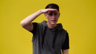 Sarı arka planda el sallayan bir adamın 4K videosu. Duyguların kavramı.