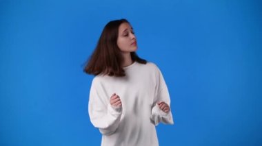 Mavi arka planda dans eden kızın 4K videosu. Duyguların kavramı.