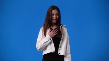 Mavi arka planda kızların yüz ifadesinin 4k videosu. Duyguların kavramı.