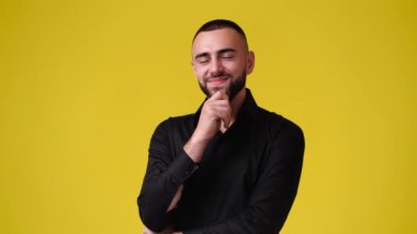 Sarı arka planda bir şey düşünen bir adamın 4K yavaş çekim videosu. Duyguların kavramı.