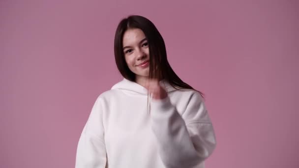 4Kスローモーションビデオの1人の女の子でホワイトパーカーポーズのビデオのためにピンクの背景 感情の概念 — ストック動画