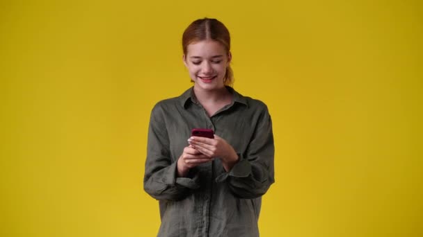Video Mujer Usando Teléfono Sobre Fondo Amarillo Concepto Emoción — Vídeo de stock