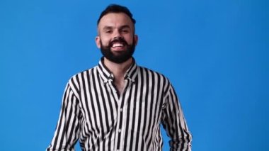 Mavi arka planda OK işareti gösteren bir adamın 4k yavaş çekim videosu. Duyguların kavramı.