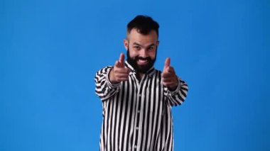 Yakışıklı bir adamın el kol hareketlerini gösteren 4K yavaş çekim videosu mavi arka planda buraya geliyor. Duyguların kavramı.