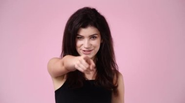 4K yavaş çekim videosu. Pembe arka planda bana işaret veren bir kızın telefon hareketi. İletişim sunan sembol kavramı.