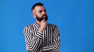 Mavi arka planda bir şey düşünen bir adamın 4K yavaş çekim videosu. Duyguların kavramı.