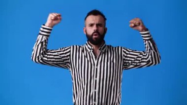 Mavi arka planda çok duygusal olan bir adamın 4k yavaş çekim videosu. Duyguların kavramı.