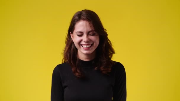 黄色い背景の上で笑っている可愛い女の子の4Kスローモーションビデオ 感情の概念 — ストック動画