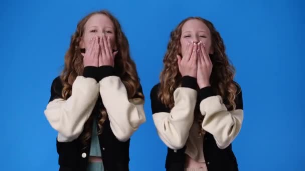 Mavi Arka Planda Hava Öpücüğü Gönderen Ikiz Kızların Videosu Duyguların — Stok video