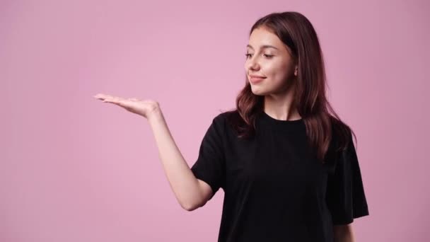 Видео Одной Девушкой Указывающей Налево Показывающей Большой Палец Розовом Фоне — стоковое видео