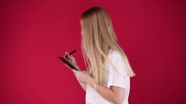 4K慢镜头 一个女孩在粉色背景下写下一些笔记 情绪的概念 — 图库视频影像