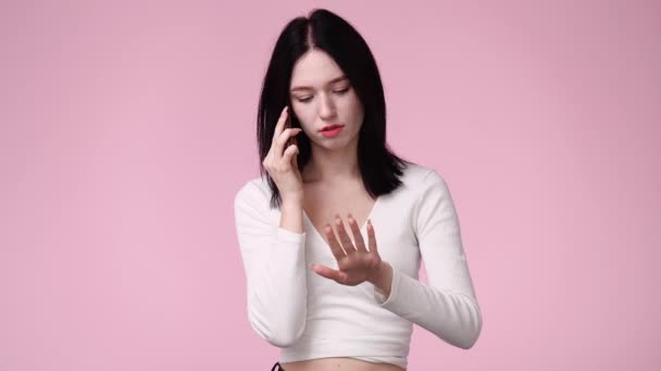 4K慢镜头 一个女孩在电话里用粉色背景说话 情绪的概念 — 图库视频影像