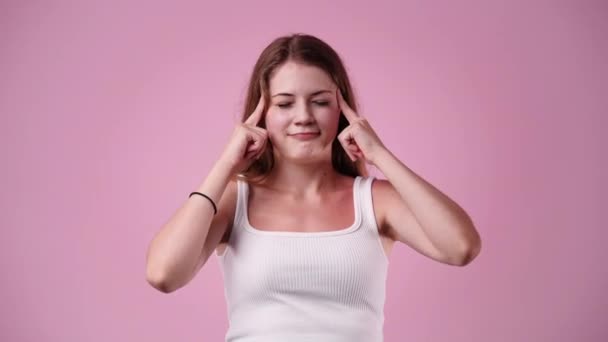 ピンクの背景に思慮深い顔の表情を持つ女の子の4Kスローモーションビデオ アイデアを持つ少女の概念 — ストック動画