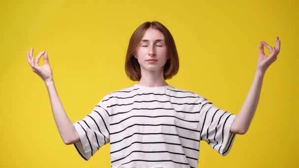 黄色い背景で瞑想している1人の少女の4Kスローモーションビデオ 感情の概念 — ストック動画