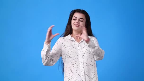 4Kビデオの女の子作る心の形に彼女の手で青の背景 愛の感情の概念 — ストック動画
