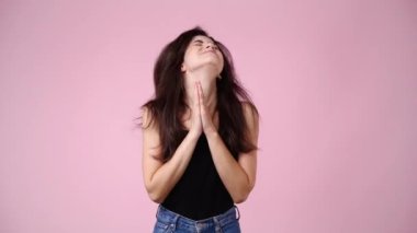 Pembe arka planda bir şey isteyen bir kızın 4K videosu. Duyguların kavramı.
