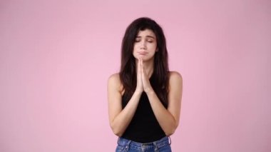 Pembe arka planda yalvaran bir kızın 4K videosu. Duyguların kavramı.
