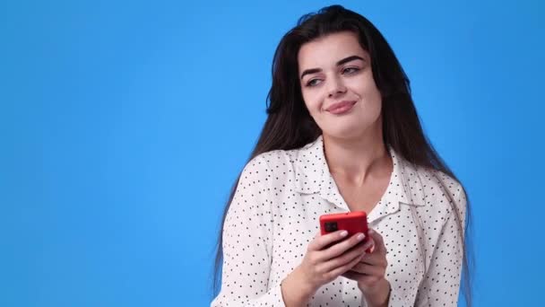 Video Una Chica Usando Teléfono Sobre Fondo Azul Concepto Emociones — Vídeo de stock