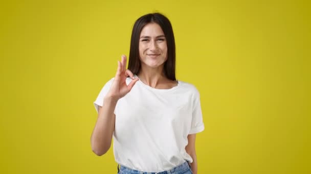 Slow Motion Video Cute Girl Showing Sign Yellow Background Concept — Stock Video