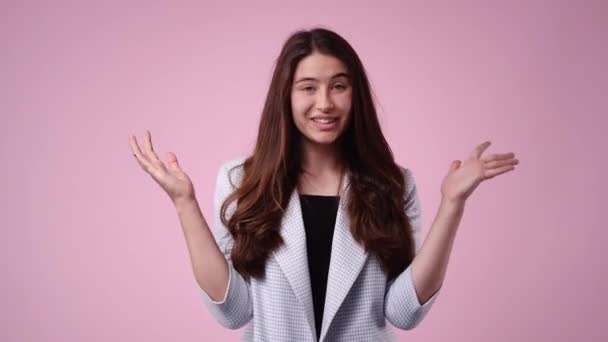 ピンクの背景に大きな目でカメラを見て驚きで手を挙げている女の子の4Kスローモーションビデオ 感情の概念 — ストック動画