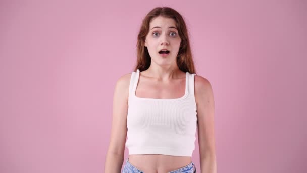 1人の女の子の4Kスローモーションビデオはピンクの背景にとても驚いています 感情の概念 — ストック動画
