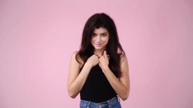 Pembe arka planda hayır diyen bir kızın 4K videosu. Duyguların kavramı.