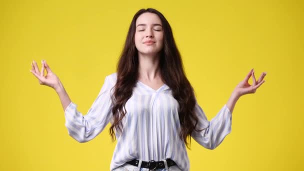 黄色い背景で瞑想している1人の女の子の4Kビデオ 感情の概念 — ストック動画