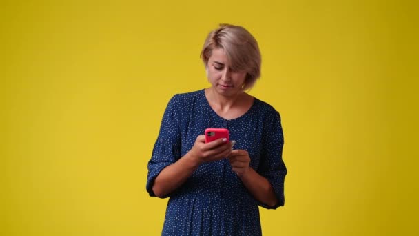Zeitlupenvideo Einer Frau Die Ihr Handy Auf Gelbem Hintergrund Benutzt — Stockvideo