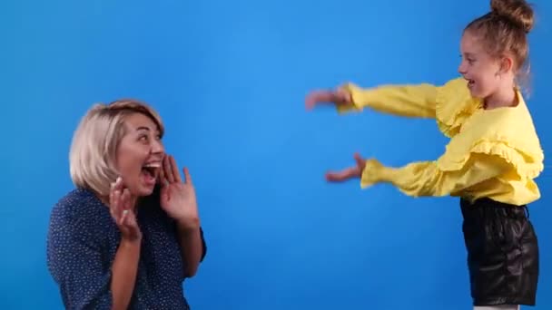 青い背景で遊んでいる子供とお母さんの4Kスローモーションビデオ 感情の概念 — ストック動画