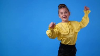 Mavi arka planda dans eden kızın 4K yavaş çekim videosu. Duyguların kavramı.