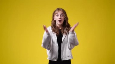 Bir kızın 4K yavaş çekim videosu sarı arka planda çok heyecanlı. Duyguların kavramı.