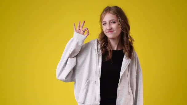 Slow Motion Video One Girl Showing Sign Yellow Background Concept — Vídeo de stock