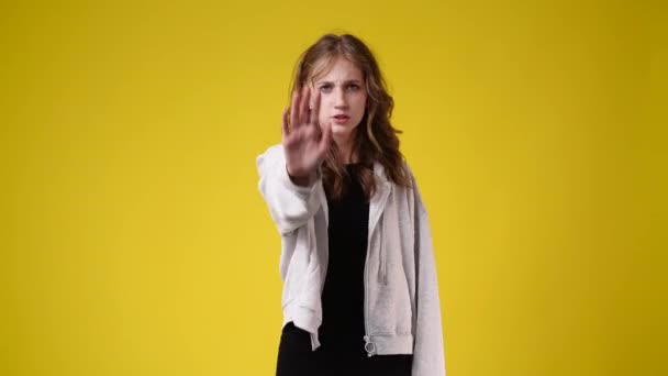 Slow Motion Wideo Jednej Dziewczyny Pokazuje Znak Stopu Żółtym Tle — Wideo stockowe
