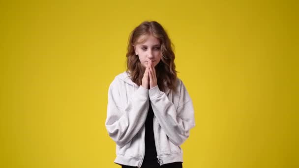 黄色の背景に狡猾な顔の表情を持つ少女の4Kスローモーションビデオ アイデアを持つ少女の概念 — ストック動画