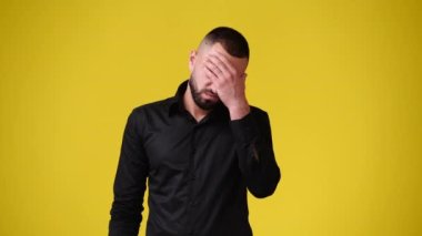 4k slow motion video of one man having headache over yellow background. Concept of emotions.