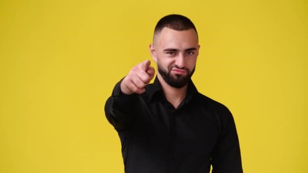 1人の男の4Kのスローモーションビデオは カメラを指して黄色の背景に親指を表示します 感情の概念 — ストック動画
