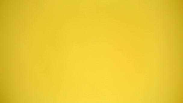 4K视频 一个男人指着相机 用黄色背景显示大拇指 情绪的概念 — 图库视频影像
