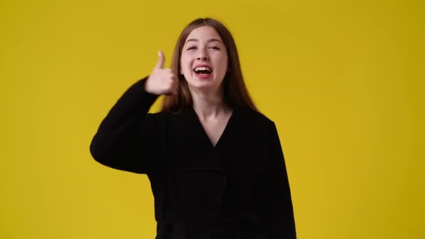 Slow Motion Video One Girl Showing Thumb Yellow Background Concept — Stock video